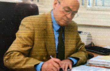 Friedrich Fuchshuber - man in brown suit - signing papers.